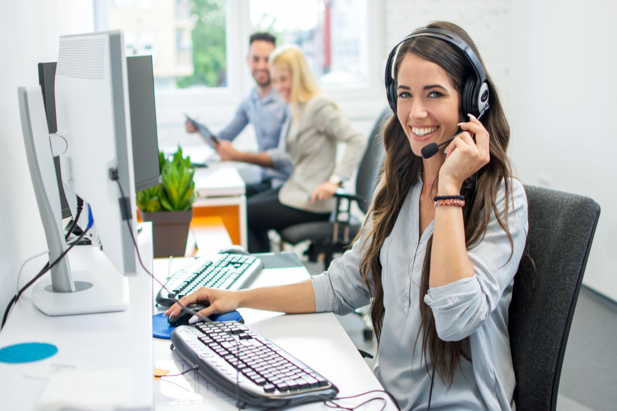 smiling-girl-taking-customer-service-calls-in-front-of-a-computer
